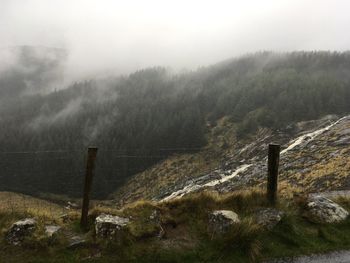 Scenic view of landscape against sky during foggy weather