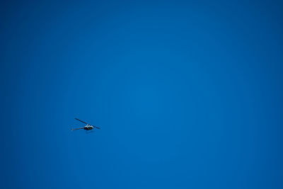 Low angle view of airplane against clear blue sky