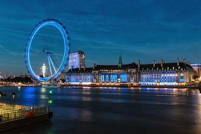 Illuminated ferris wheel in city at night