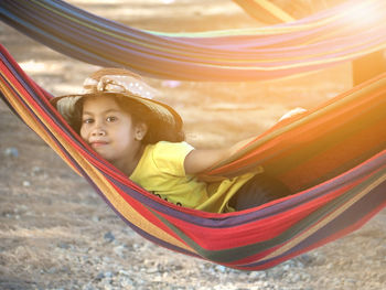 Rear view of girl on hammock at playground