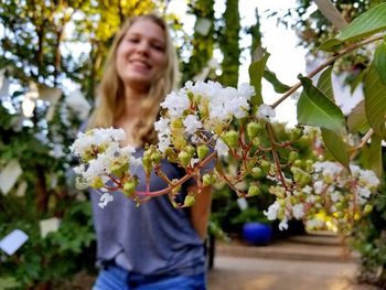 Young woman smiling amidst flowering plants