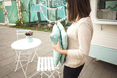 Side view of owner holding cushions outside food truck on street