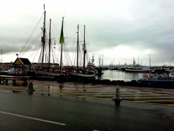 Sailboats moored at harbor