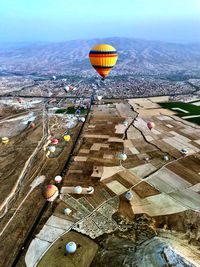 High angle view of hot air balloon flying over city