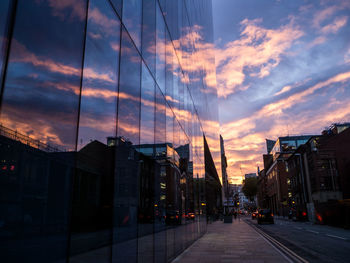 Modern building in city against sky during sunset