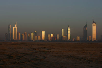 Emirates towers and skyscrapers against sky during sunrise