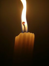 Close-up of illuminated candle against black background