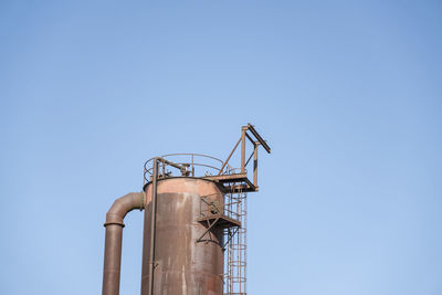 Low angle view of crane against clear blue sky