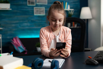 Side view of boy using mobile phone at home