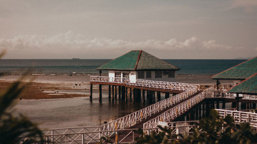 Pier over sea against sky during sunset