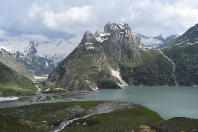 Scenic view of mountains and river against cloudy sky