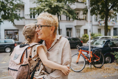 Granddaughter embracing grandmother at street