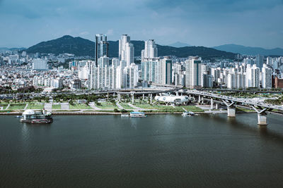 Scenic view of river by buildings against sky in city