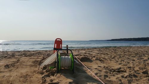 Deck chairs on beach against clear sky