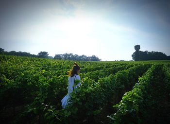 Rear view of man on field against sky