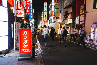 People walking on road in city at night