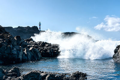 Rocks in sea against clear sky