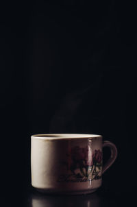 Close-up of coffee cup against black background