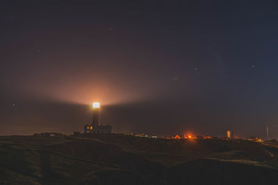 Illuminated buildings against sky at night