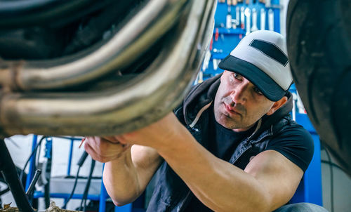 Mature mechanic repairing motorcycle in garage