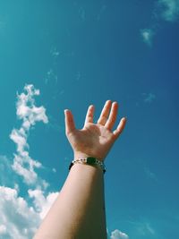 Low angle view of hand against blue sky