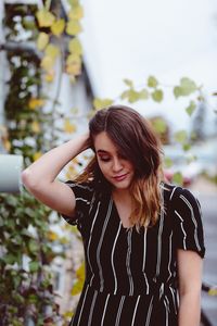 Close-up of young woman standing against tree