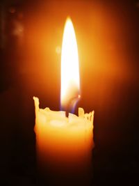 Close-up of lit candle in the dark