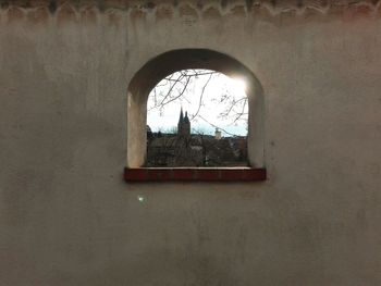 Built structure against sky seen through window