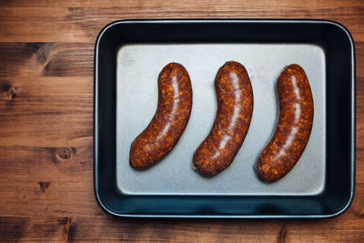 High angle view of roasted sausages in plate on table