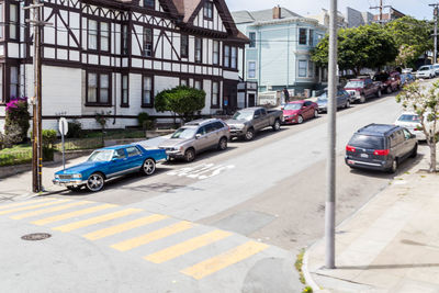 Vehicles on road by buildings in city