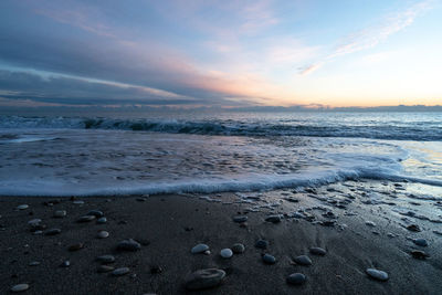 Scenic view of beach against sky during sunrise