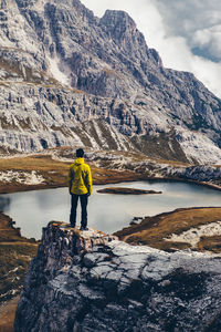 Rear view of woman standing on rocky mountain