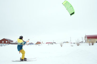 Man on snow covered land against sky