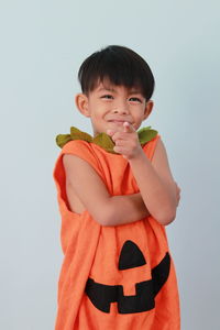 Portrait of cute boy standing against gray background