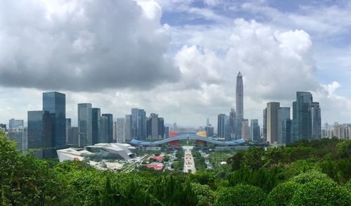 View of skyscrapers in city against cloudy sky