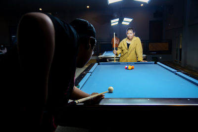 Midsection of man playing pool