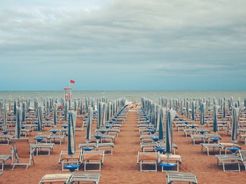 Chairs on beach against sky