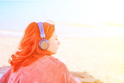 Portrait of woman looking at sea shore against sky