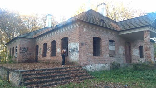 Low section of woman standing by building against sky