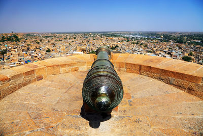 Canon on fort overlooking townscape against clear sky