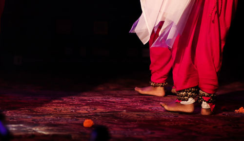 Low section of woman standing on red floor