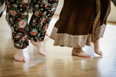 Low section of women standing on hardwood floor