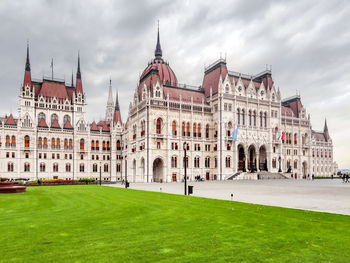 Buildings in city against cloudy sky