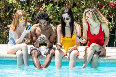 Group of people sitting at swimming pool