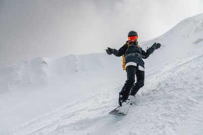 Snowboarder bent over and brakes on a freeride slope. active man snowboarder rides on the slope. ski