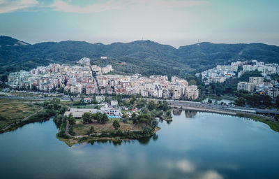 River amidst buildings in city against sky