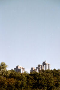 Buildings in city against clear sky