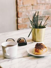 Close-up of coffee served on table against wall