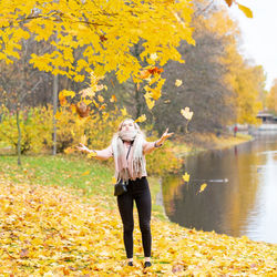 Full length of girl standing on yellow autumn leaves