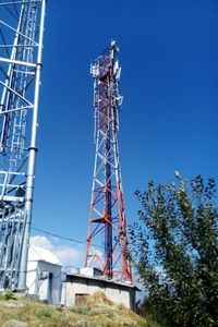 Low angle view of communications tower against blue sky